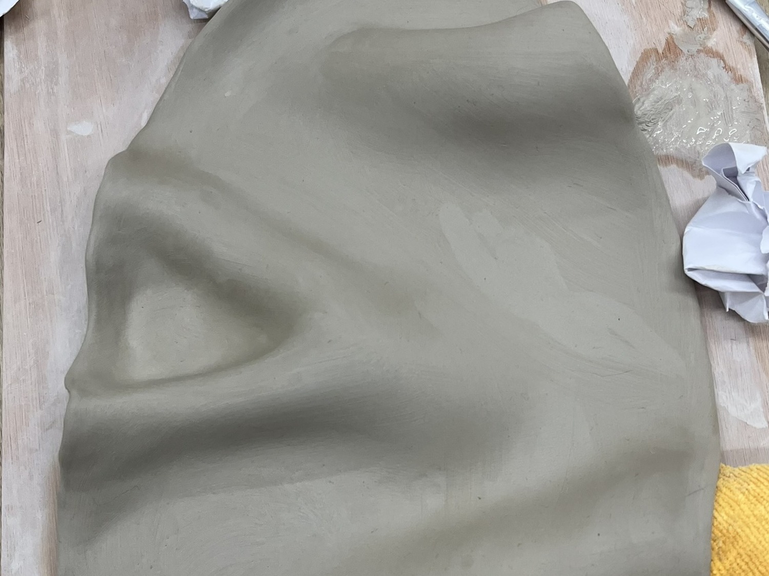 Hand-built clay form with soft folds and surface texture, made in the workshop