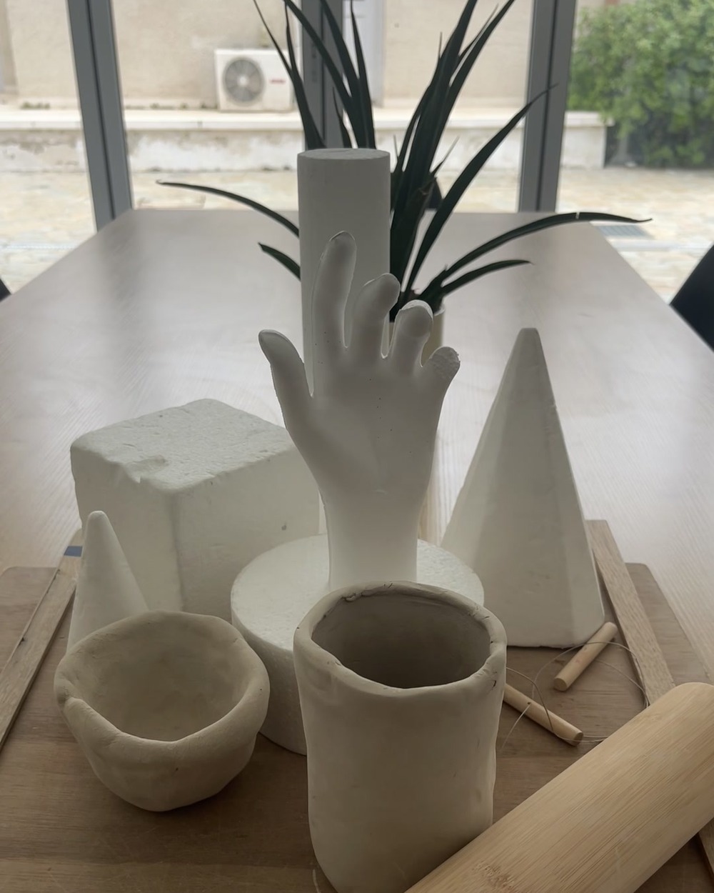 Ceramic still life sculptures on a workbench at Arte Fino studio